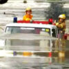 冠水道路を進む消防車