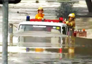 冠水道路を進む消防車