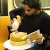 地下鉄でケーキを作る女性